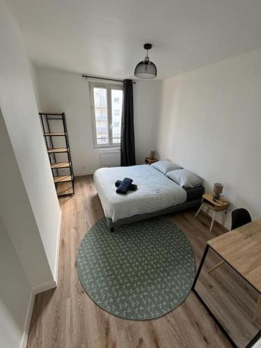 une chambre avec un lit et un tapis vert dans l'établissement Le spacieux, au Havre