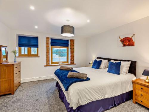 a bedroom with a large bed with blue pillows at 2 Bed in Clun 94099 in Clun