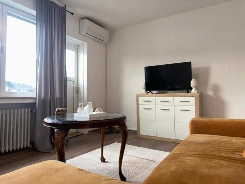 ein Wohnzimmer mit einem TV und einem Couchtisch in der Unterkunft Penthouse Köln- Frechen 80qm 3 Zimmer in Frechen