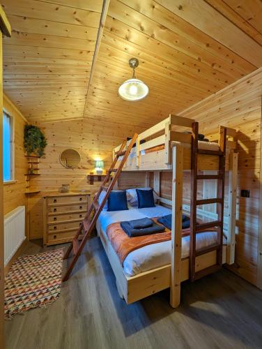 a bedroom with two bunk beds in a log cabin at Ferry Lodge Norfolk Broads in Brundall