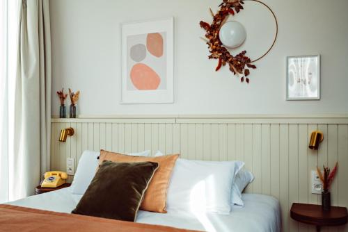 a bedroom with a bed and a wreath on the wall at Hôtel Maison Lacassagne Lyon in Lyon
