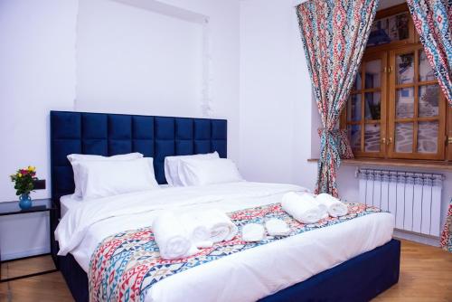 a bedroom with a large bed with towels on it at Pallada in Yerevan