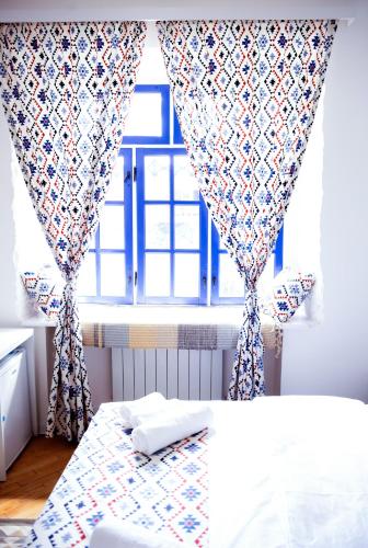 a bedroom with a bed and a window with curtains at Pallada in Yerevan