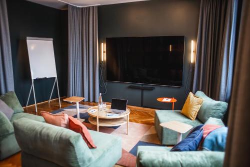 a living room with two couches and a tv at The Circus Apartments in Berlin