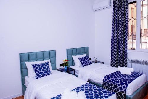 a room with two beds and a window at Pallada in Yerevan
