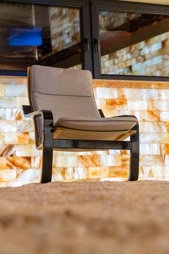 a chair sitting in front of a brick wall at Transylvania House in Arieşeni
