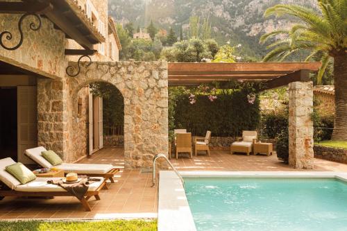 a patio with a swimming pool next to a house at La Residencia, A Belmond Hotel, Mallorca in Deia