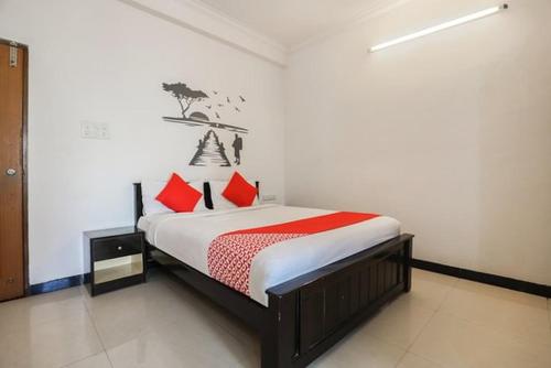 um quarto com uma cama com almofadas vermelhas em Nallur mylooran Arangam em Chiviyateru West