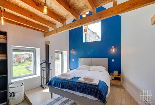 a bedroom with blue walls and a large bed at L'escapade / Maison de campagne in Veigné