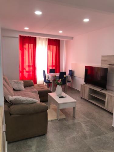 ein Wohnzimmer mit einem Sofa und einem Flachbild-TV in der Unterkunft Apartamento La Plana II in Castellón de la Plana