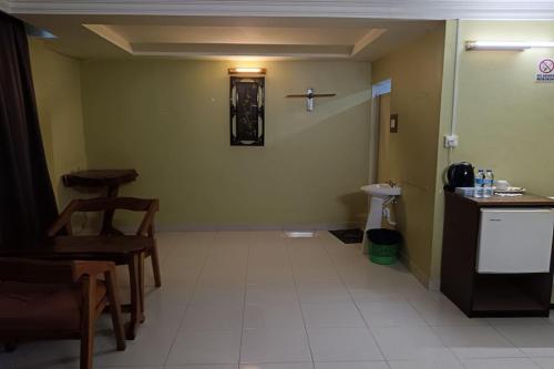 a room with a toilet and a table and chairs at Fins Hotel, Alor Setar in Alor Setar