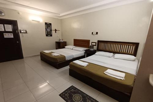 Habitación de hotel con 2 camas y baño en Fins Hotel en Alor Setar