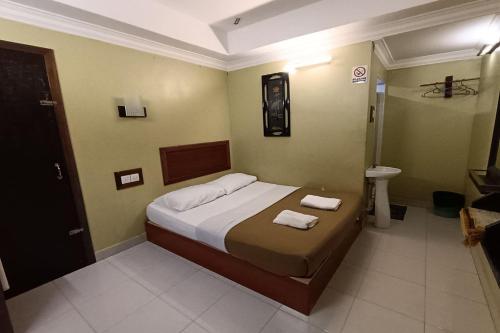 a bedroom with a bed with two towels on it at Fins Hotel in Alor Setar