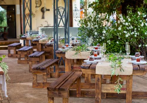 a row of wooden tables and benches with plants on them at Imbabali Retreat & Venue in Magaliesburg