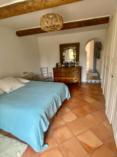 - une chambre dotée d'un lit bleu et de carrelage dans l'établissement Mas dans son écrin de verdure, à Orange