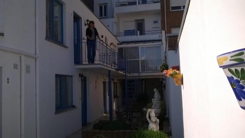 a man standing on the balcony of a building at Kokodor in De Haan