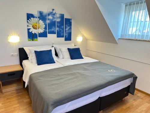 a bedroom with a large bed with blue pillows at Boutique Hotel Loka in Škofja Loka