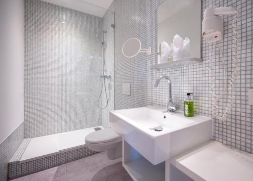 a bathroom with a sink and a toilet and a shower at The New Yorker BOARDINGHOUSE in Cologne