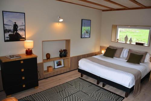 a bedroom with a large bed and a window at Le clos de la lande vallée in Bringal