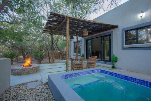 a house with a swimming pool and a fireplace at EDJAMI Guest House in Marloth Park