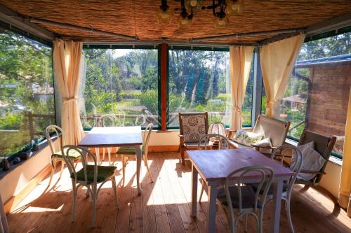 Licciana NardiにあるB&B Cadrecca Tra Terra Luna e Mareのテーブルと椅子、大きな窓が備わる客室です。