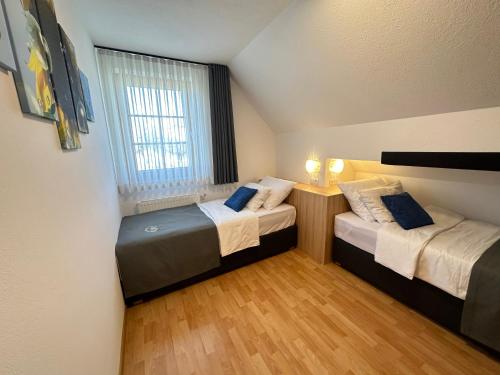 two beds in a small room with a window at Boutique Hotel Loka in Škofja Loka