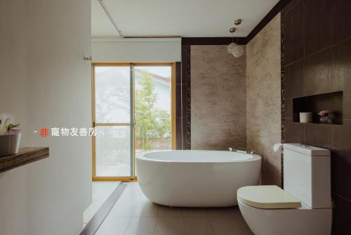 a white bath tub in a bathroom with a window at Dao Villa in Dongshan