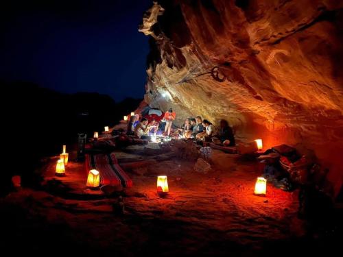 a group of people sitting in a cave with candles at Hasan Zawaideh Camp in Wadi Rum