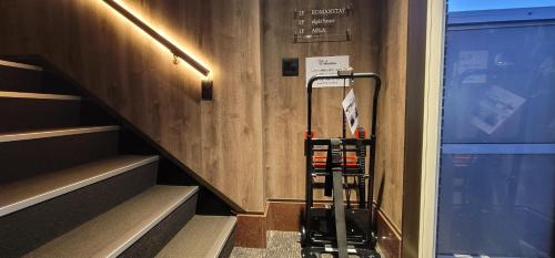 a luggage cart sitting next to a stair case at ROMANSTAY in Takayama