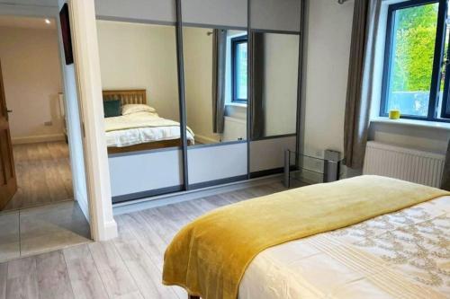 una camera con un letto e un grande specchio di Aghadoe Millers - Modern 3 bed house Killarney a Fossa