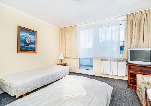 a hotel room with two beds and a tv at Baltic Plaza Gdynia - MAXIMAL in Gdynia