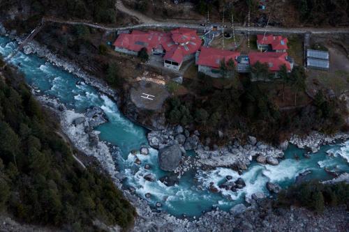 an aerial view of a house next to a river at Mountain Lodges of Nepal - Phakding in Phakding
