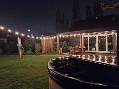 a backyard with a pool at night with lights at In de bocht - Hottub Sauna in Gemonde