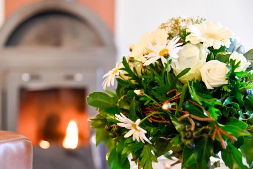 a bouquet of white flowers in front of a fireplace at Landhotel Burg im Spreewald - Resort & Spa in Burg