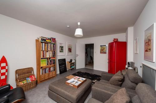 a living room with a couch and a red refrigerator at Chez RG in Bruges
