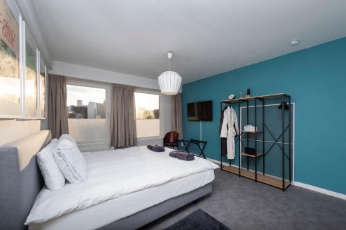 sypialnia z dużym łóżkiem i niebieską ścianą w obiekcie Chez RG w Brugii