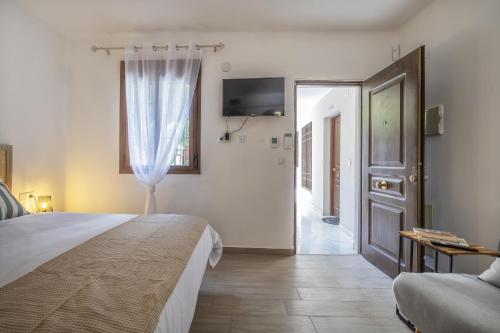 a bedroom with a bed and a door with a television at El rincón de la Chiquita & Parking in Córdoba
