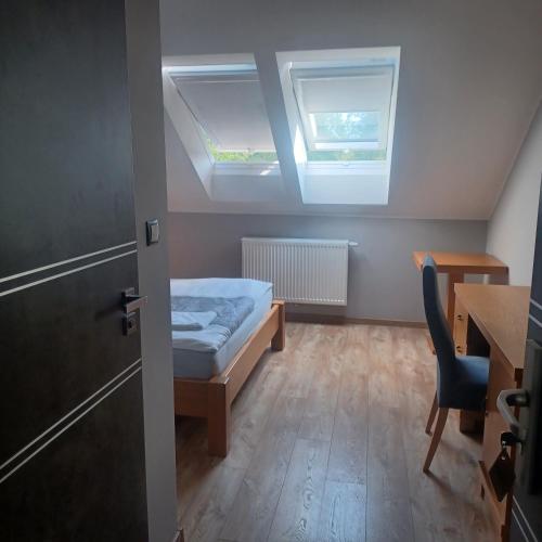 Zimmer mit einem Bett, einem Schreibtisch und einem Fenster in der Unterkunft Pensjonat Magnolia in Przejma Wielka