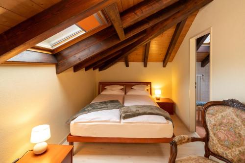 1 dormitorio con 1 cama en una habitación con techos de madera en Locanda Villa d' Epoca, en Aurigeno