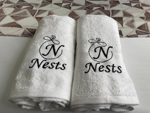 Kericho的住宿－Oak Nest，两条毛巾,写着字母n,单词nesty