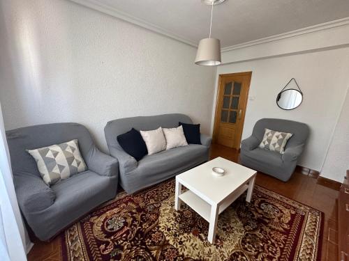 a living room with two couches and a table at Casa Gerardo in Ribadesella
