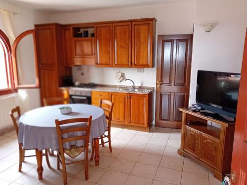 a kitchen with a table with chairs and a television at Bandi House in San Teodoro