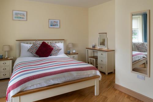 a bedroom with a bed and a mirror at Puffin View in Llanfairfechan