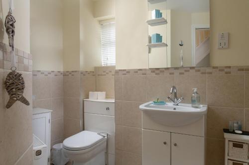 a bathroom with a toilet and a sink at Orme View in Llanfairfechan