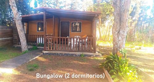 a cabin in the woods with a porch and two chairs at La posada in Chiclana de la Frontera