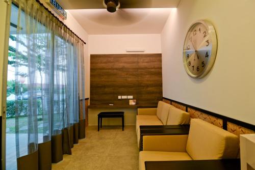 a waiting room with couches and a clock on the wall at Parkview Homes in Ipoh