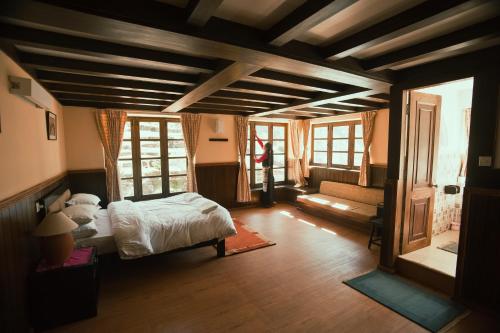 1 dormitorio con 1 cama y sala de estar en Mountain Lodges of Nepal - Monjo en Monjo