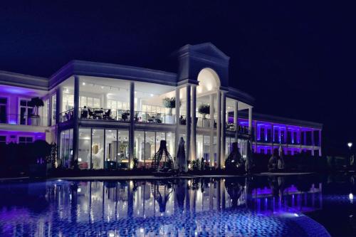 un edificio con luces moradas por la noche en Velipoja Grand Europa Resort, Affiliated by Melia, en Velipojë