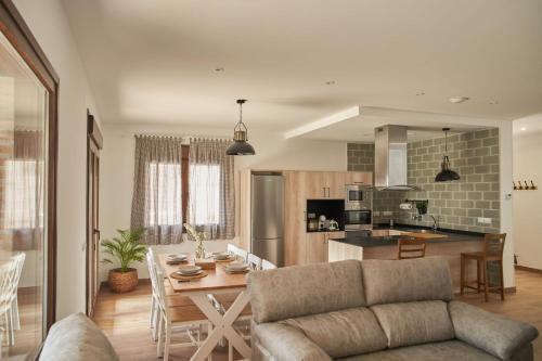 a living room and kitchen with a table and a couch at Casas Rurales El Aljibe, Jara in Argés