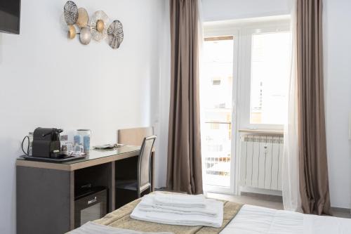 een slaapkamer met een bureau, een bed en een raam bij 247 Luxury Rooms Trastevere in Rome